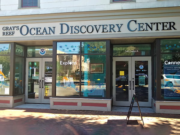 A store front building along a brick sidewalk with the title: Gray's Reef Ocean Discovery Center