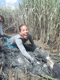 Michelle Rodabaugh crawls through the thick, sticky mud of the salt marsh into a tidal creek