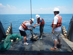 Kevin Faircloth and Kaitlin Dunn operate a sediment grab to collect a bottom sample from the sea floor