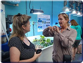 GRNMS Foundation chair Cathy Sakas (R) explains coral growth to teacher Kelli Bivins (L) at Georgia Aquarium