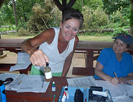 Leslie Wallace (L) and Kelli Bivins (R) learn to test water quality at the Towaliga River.