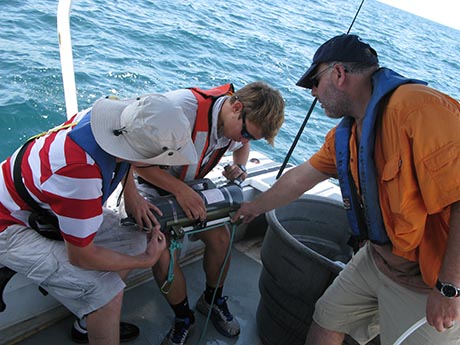 UGA summer students Dylan Ward (l), Taylor Faulk (c) and  UGA/SkIO professor Dr. Marc Frischer (r) prepare niskin bottle for water sample deployment in Gray's Reef.