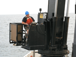 A crane operator moves dive boats between the ship and the ocean. 