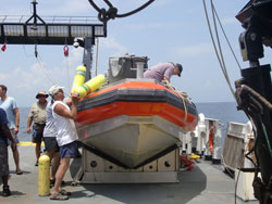Divers load tanks and gear into small boats.